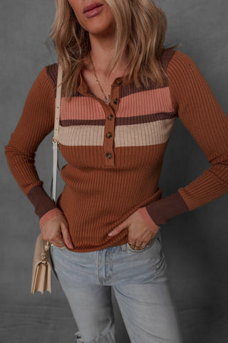 women modeling a stripe detail button front henley. The colors on the henley are a burnt orange with cream, brown, and pink contrasting stripes