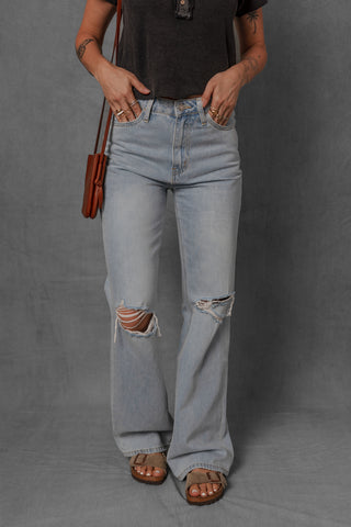 women modeling light wash denim jeans with distressed knees